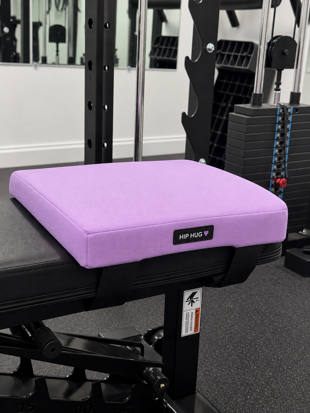 Lavender HIPHUG foam pad strapped to a flat weight bench with the HIP HUG label visible